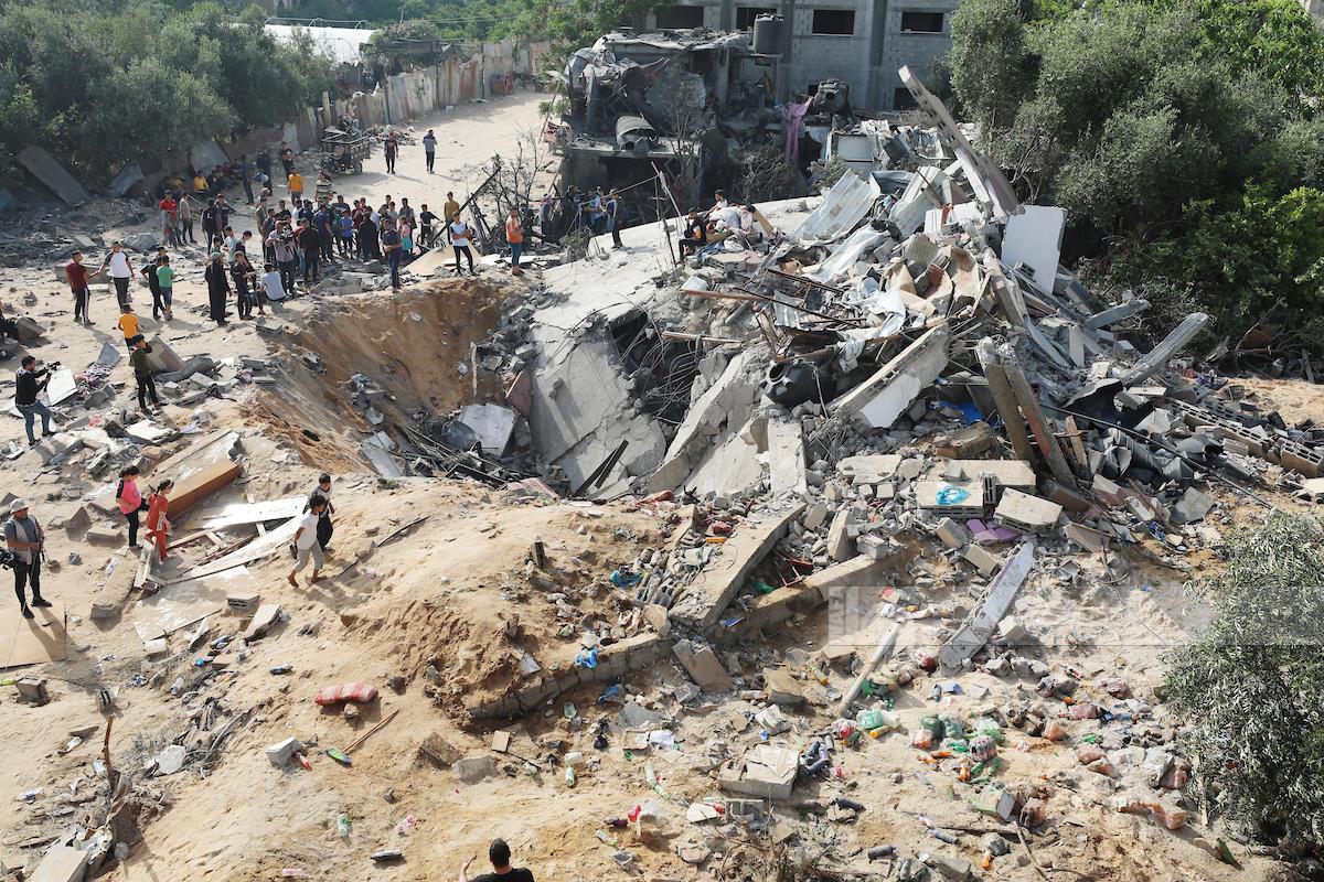 مواطنون يتفقدون آثار الدمار الذي خلفته غارة جوية على بيت لاهيا شمال غزة